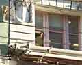 Man at window of masonry building.